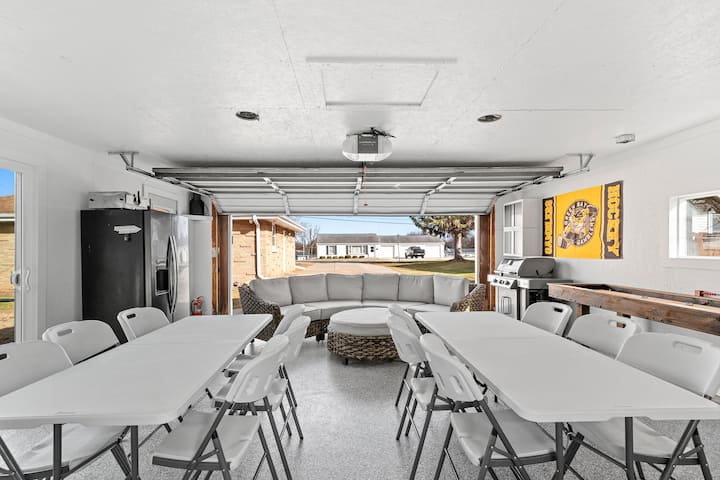 Garage hangout with long tables, a sectional and Packers decor