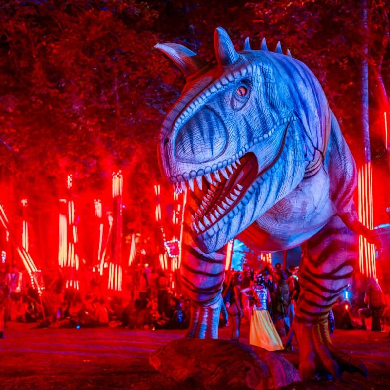 Dinosauří dekorace ve večerním areálu festivalu Lost Lands