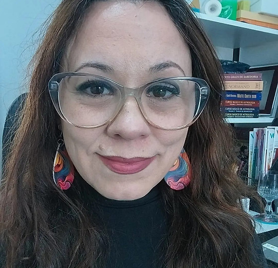 A imagem mostra uma mulher de cabelos longos e castanhos, soltos sobre os ombros. 