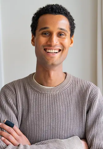 Ken Darko smiling with his arms crossed