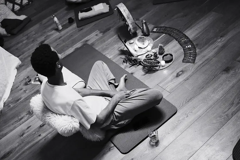 man sitting crossed legged in front of an altar during breathwork ceremony