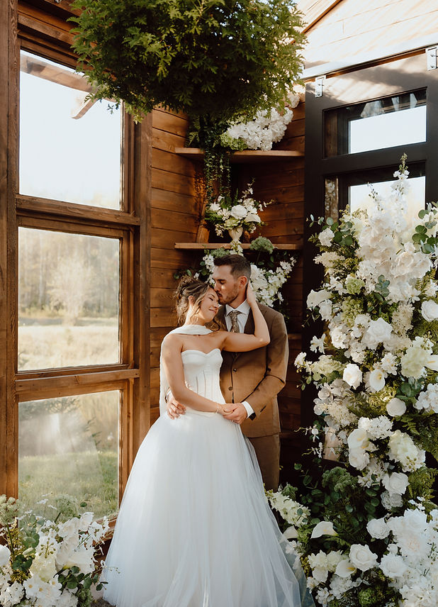 Prince Edward Island Wedding Photography captures bride and groom among many florals. 
