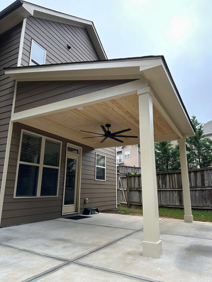 This outdoor living space is complete with a concrete patio with a 12x13 roof cover.
Roof Cover features tongue and groove ceiling, trim package, an outdoor fan, (2) recessed LED lights, and (1) outlet in the ceiling for a TV.