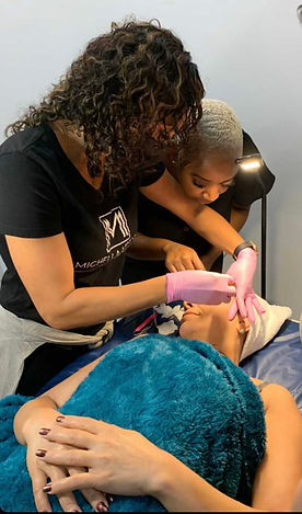 Nicole training another female how to wax eyebrows