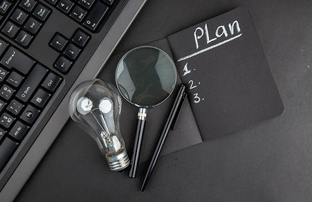 top-view-plan-written-black-notepad-lupa-keyboard-light-bulb-pen-black-table.jpg