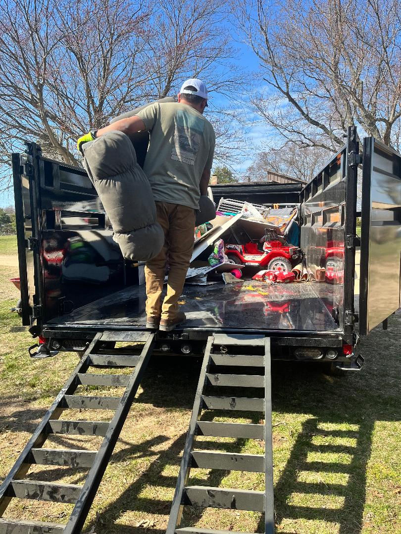 Person loading junk into trailer for local junk removal.