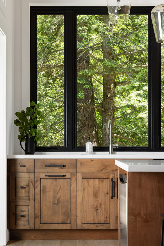 Nature view from Muskoka cottage kitchen, black window frames, rustic wood cabinetry, quartz countertop