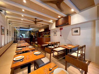 Dining layout and seating composition within contemporary shophouse restaurant