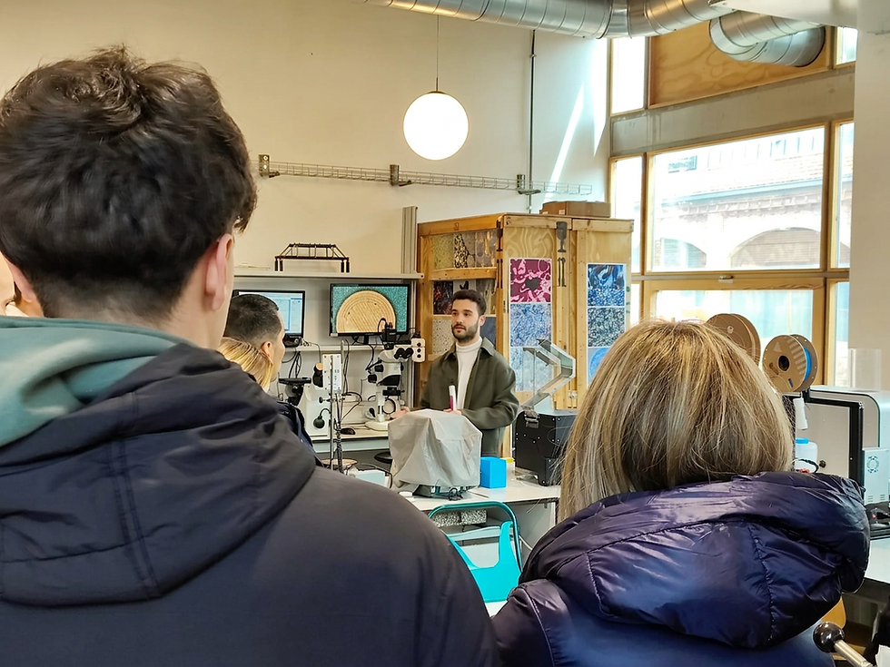 Research laboratory visit explaining ongoing research lines, with a particular focus on additive manufacturing, while a material micrograph is displayed on the computer screen in the background.