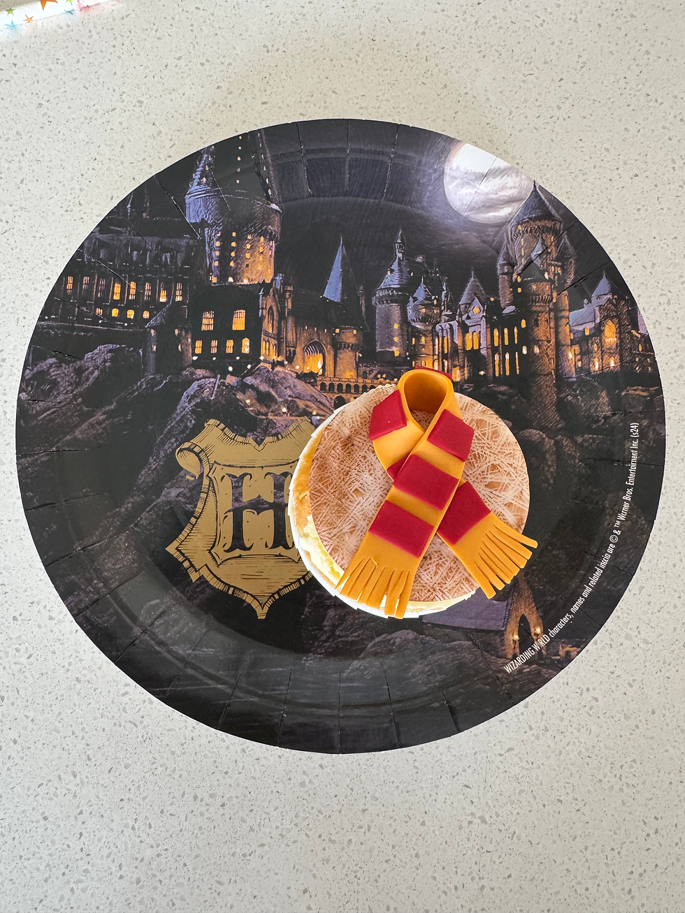 Cake with a red and yellow scarf decoration on a Harry Potter plate