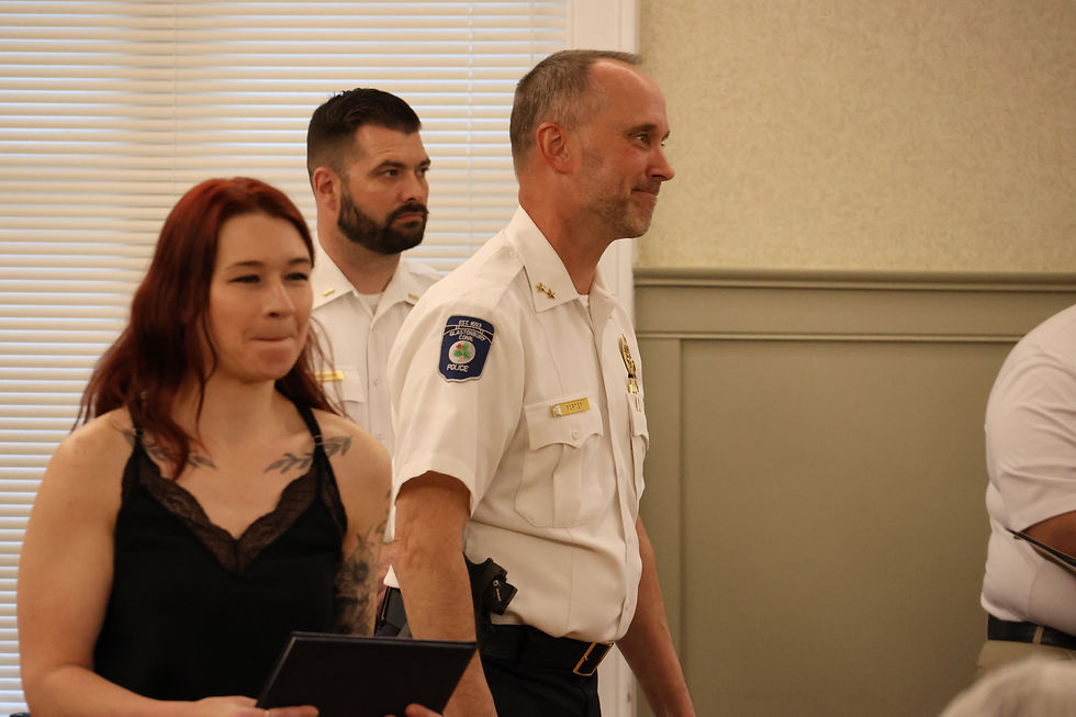 Police Chief Marshall Porter smiles after handing an award to Christina Bona for helping to organize a women’s self-defense course. (Marteka)