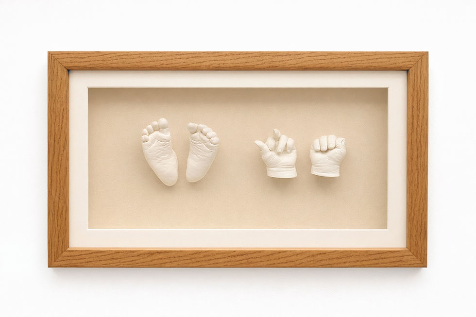 Framed plaster baby hands and feet cast in a classic landscape layout.