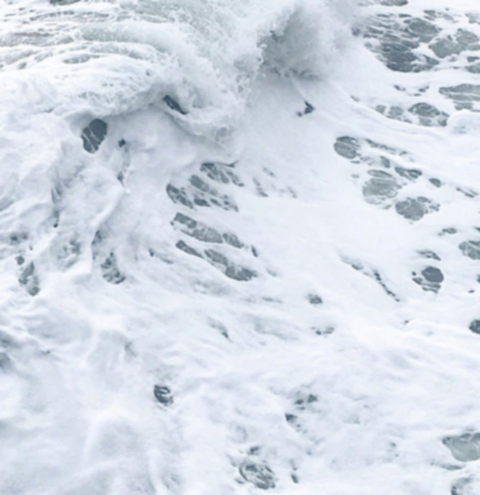 Closeup image of white frothing ocean where waves crash.