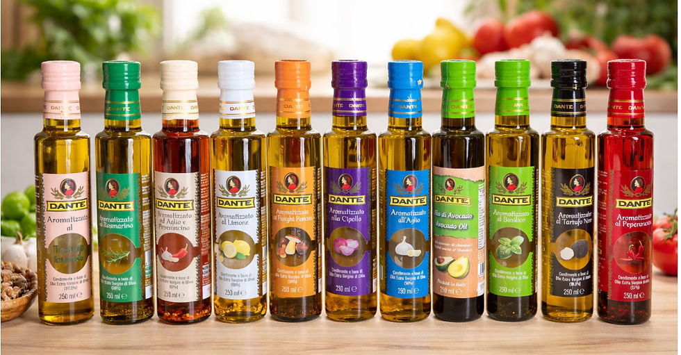 Row of colorful Dante flavored olive oil bottles on a kitchen counter, with blurred fresh produce in the background.