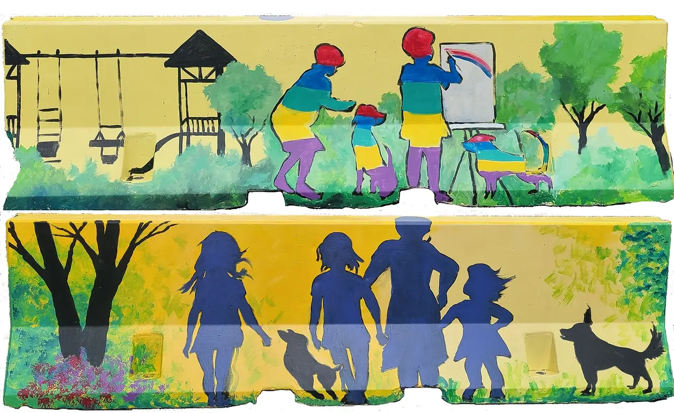 concrete barriers with a painted yellow background, green trees, and silhouettes of families and pets enjoying city parks