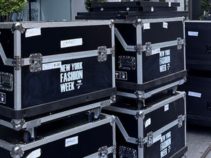 Stacked equipment cases on display outside a building for New York Fashion Week.