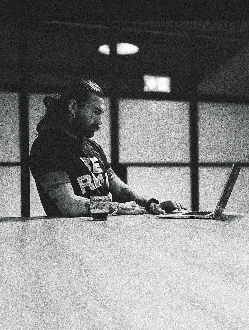 Man working on a laptop planning his nutrition and workouts