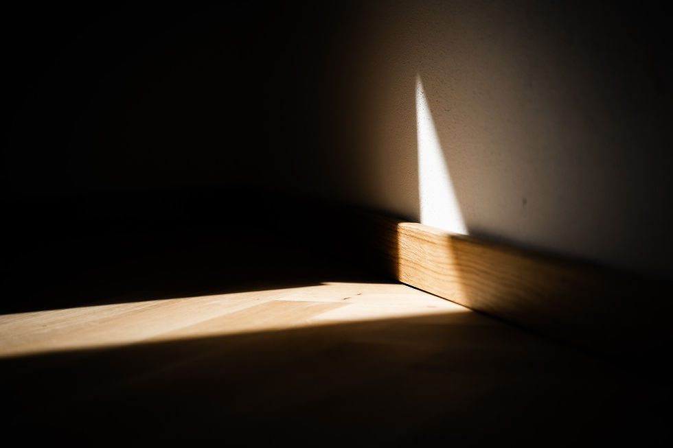 Ein Lichtstreifen der auf einen Holzboden fällt.