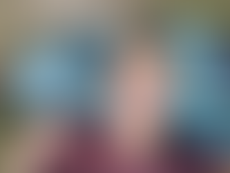 Une jeune femme est couchée dans l'herbe. Sa tête est posée sur un sac à dos de randonnée bleu