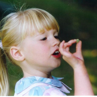 Portrait d'une petite fille blonde qui joue avec des boules de tilleul