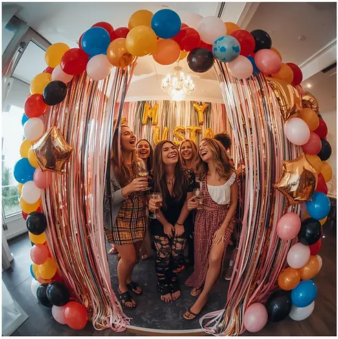 Amies riant sous une arche de ballons