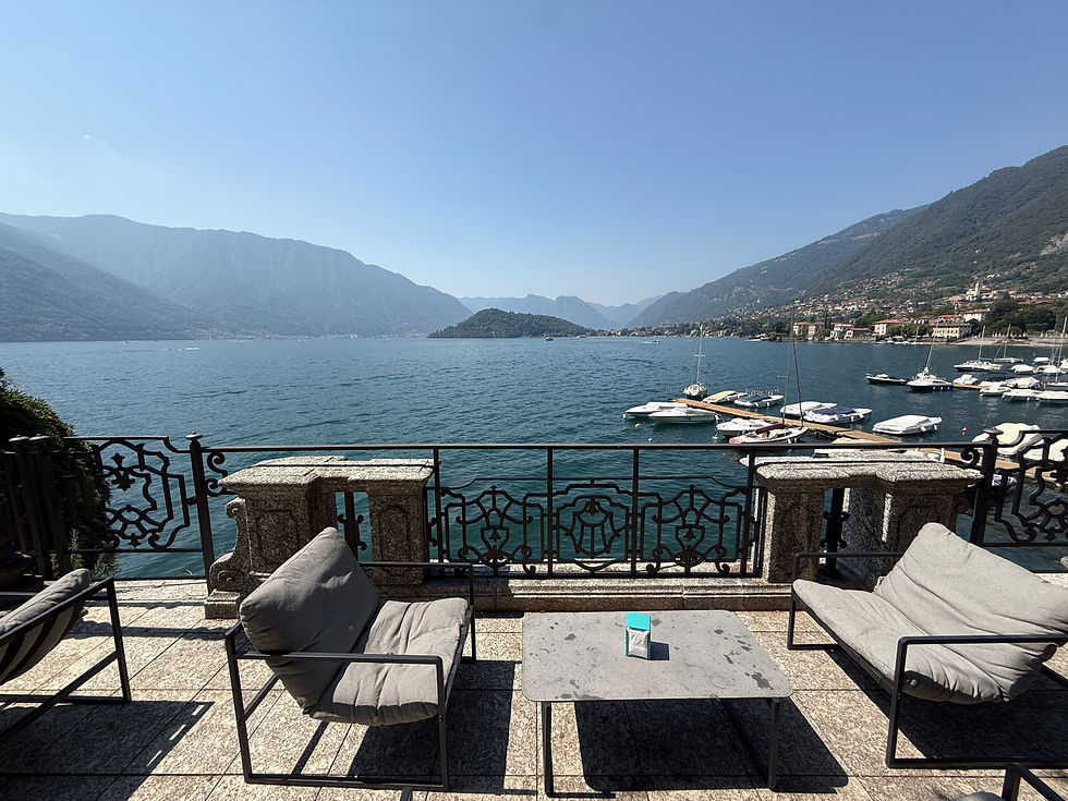 Lakeside terrace seating overlooking boats and mountains at Lake Como