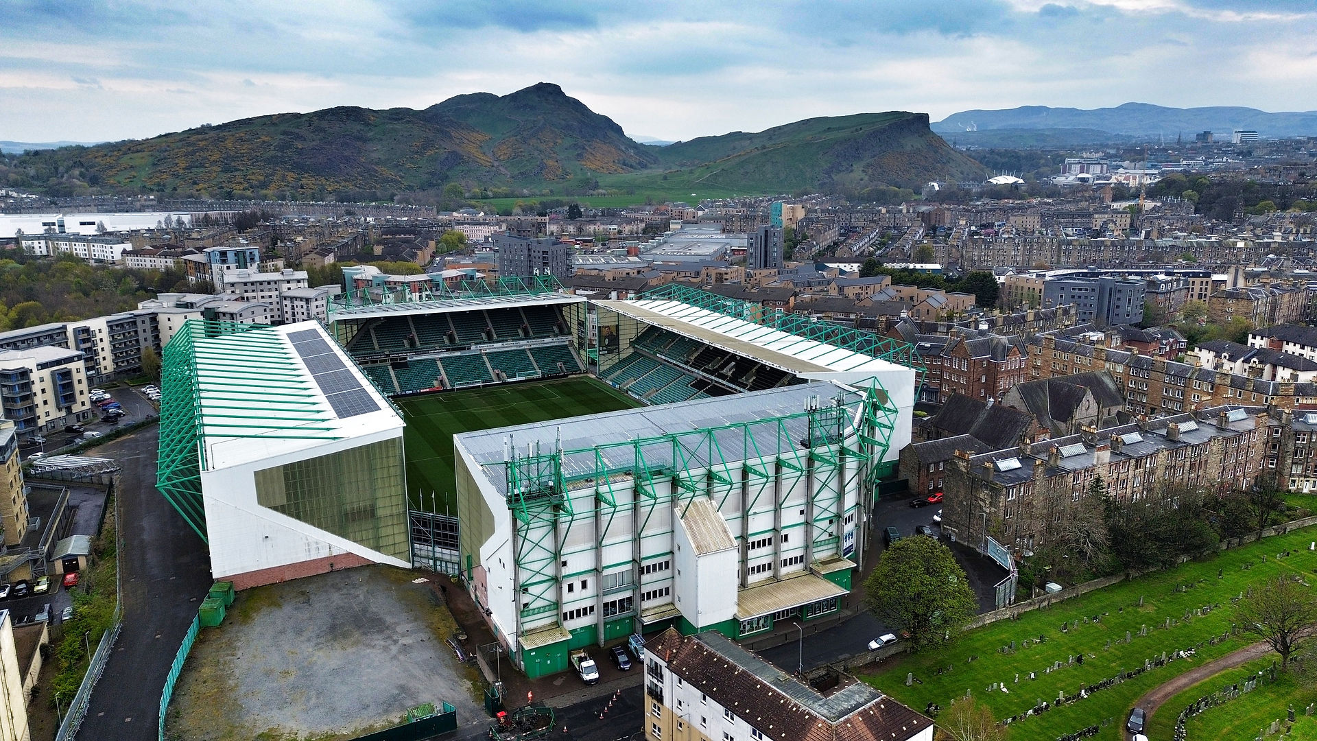 Football stadium with a hill in the background. Hibernian FC home football ground Easter Road and Arthur's Seat in the background. 