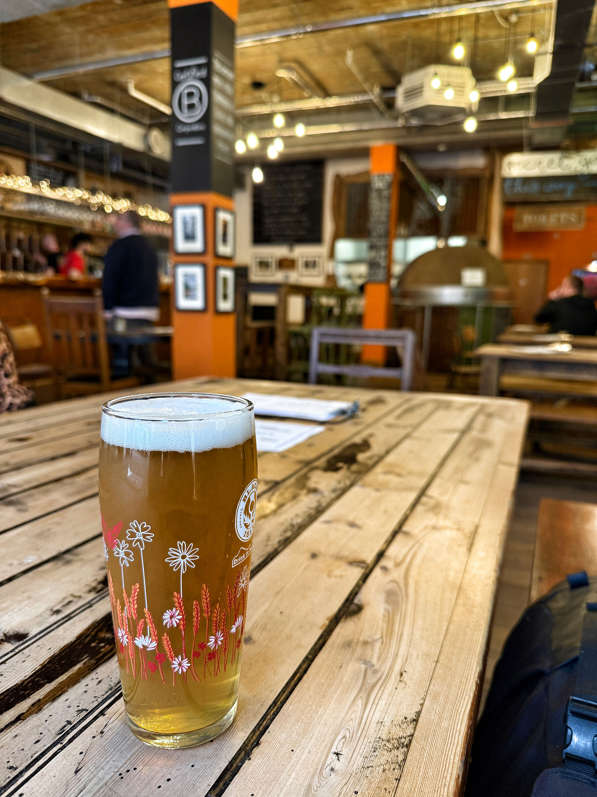 Pub with pint of beer, quiet pub with pint of beer, wooden tables, pizza oven, colourful decorations