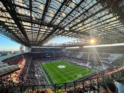 View across the San Siro Stadium during a football match as the sun sets through the roof