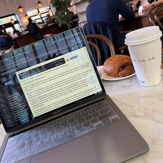 A writing program open on a laptop in a cafe