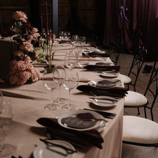Wedding styling detail with glassware, linen textures and soft candlelight reflections