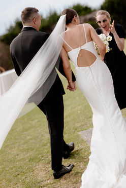 Wedding planner excitedly approaching a newly wed couple