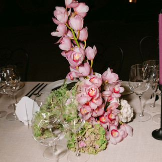 Wedding floral styling featuring cascading orchids and soft blush roses on reception table