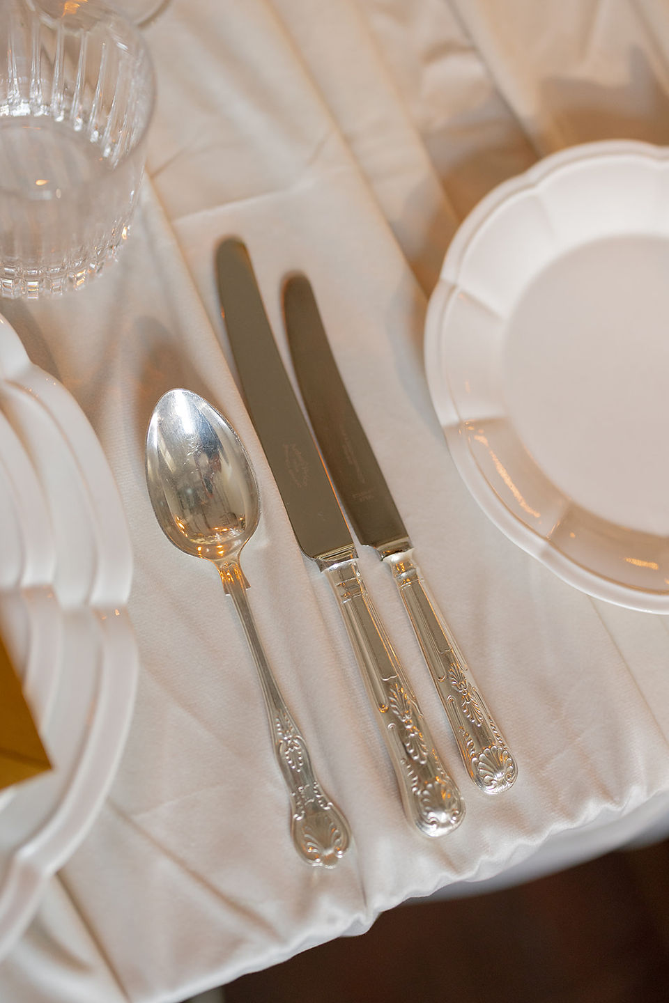 Wedding table styling featuring textured linens and polished silver details