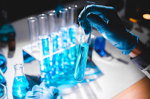 hand-in-blue-glove-holding-vial-of-blue-