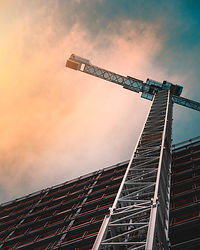 There is a crane and a half finished building being completed, it is a construction area and this is a real estate project development of PMY Ventures