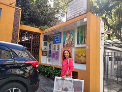 Artista plástica Fátima Münch entregando obras de arte para exposição