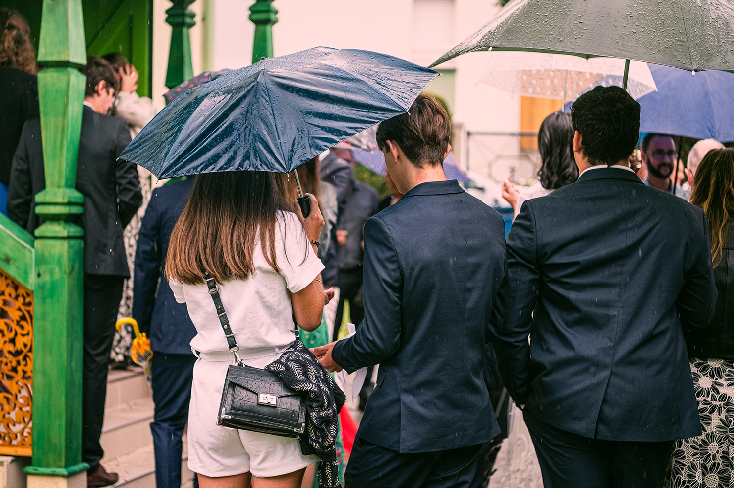 Des invités de mariage orthodoxe qui attendent sous la pluie