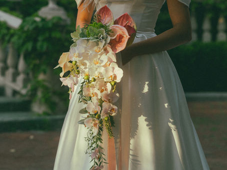JW Weddings bride holding waterfall bouquet in pink and white with orchid cascade