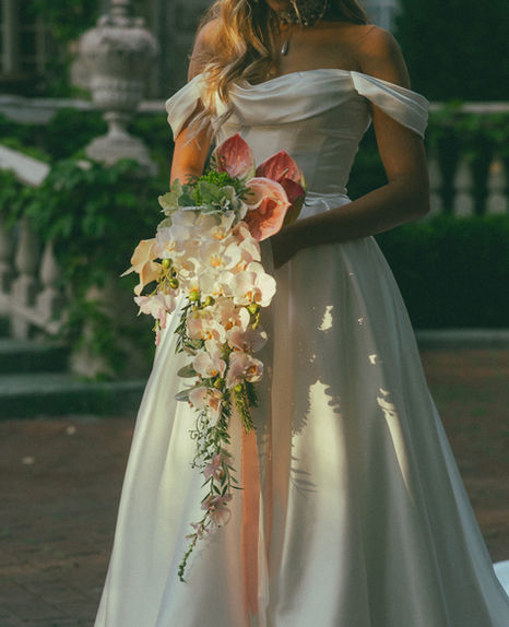 JW Weddings bride holding waterfall bouquet in pink and white with orchid cascade
