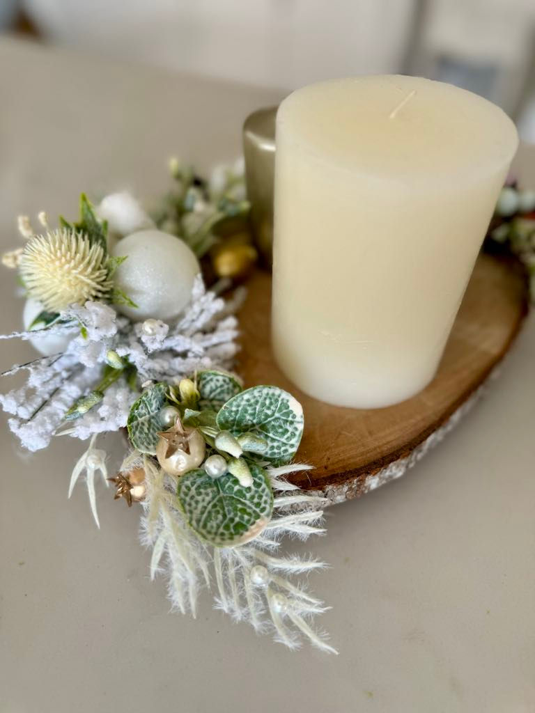 Elegant Christmas candle display on a wood slice base, featuring one ivory pillar candle and two metallic gold candles, surro