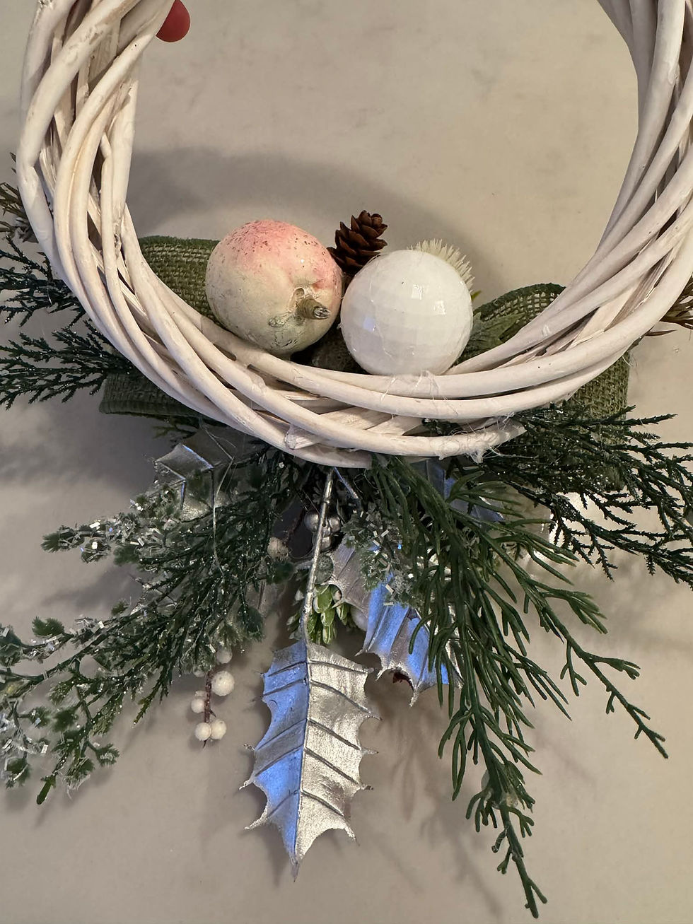 Thumbnail: Back of petite Christmas wreath showing foliage and assortment of baubles.