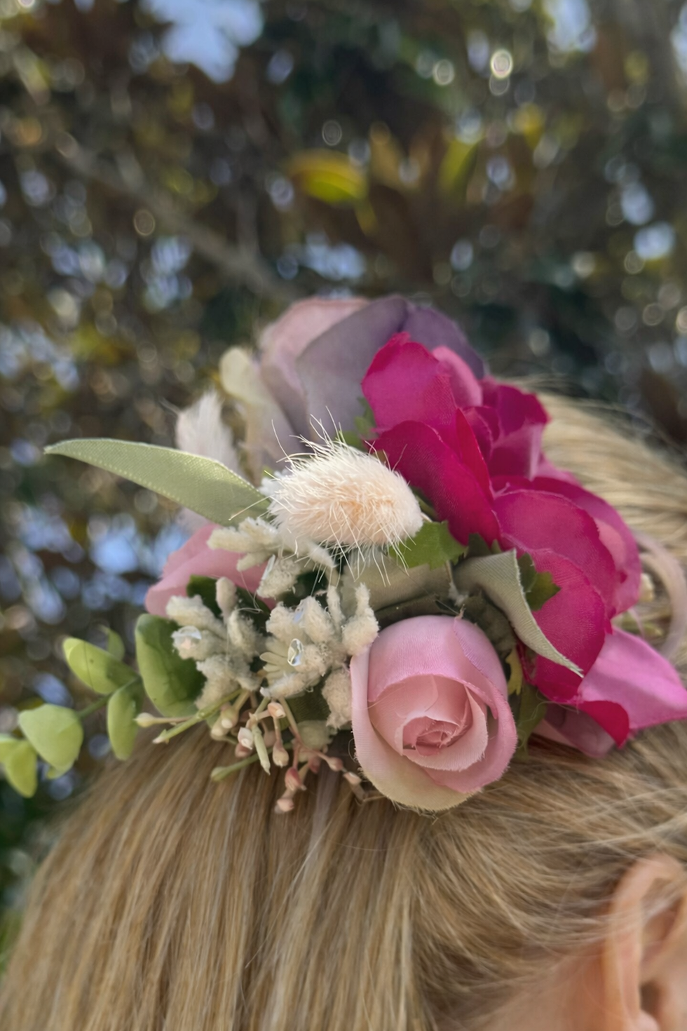 Close shot of JW Weddings floral headband with dusty pink rose, fuchsia peony and green foliage against blonde hair