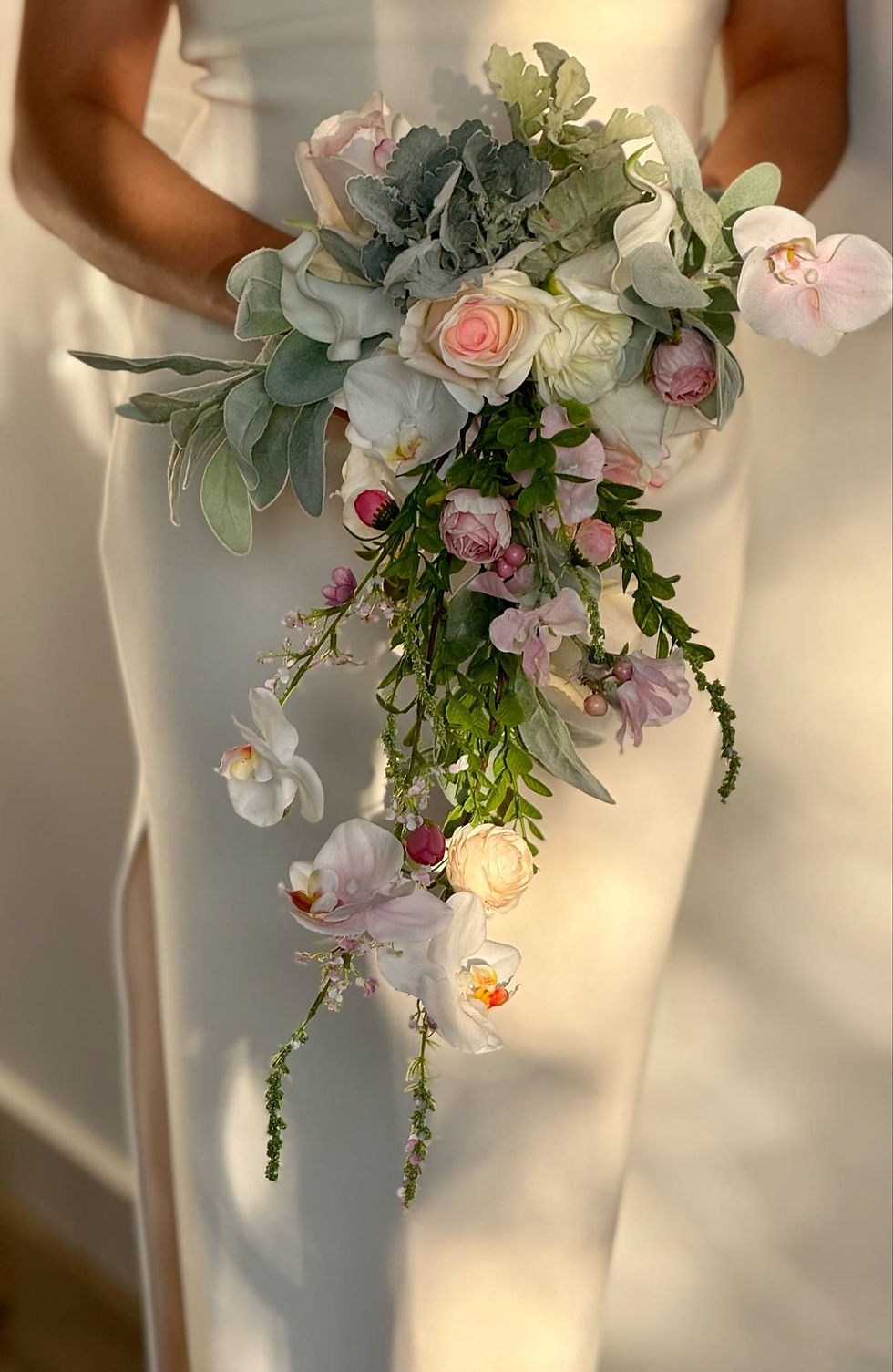 Thumbnail: Wedding bouquet, low section, showing trail with orchid, peonies and green foliage drenched in sunlight