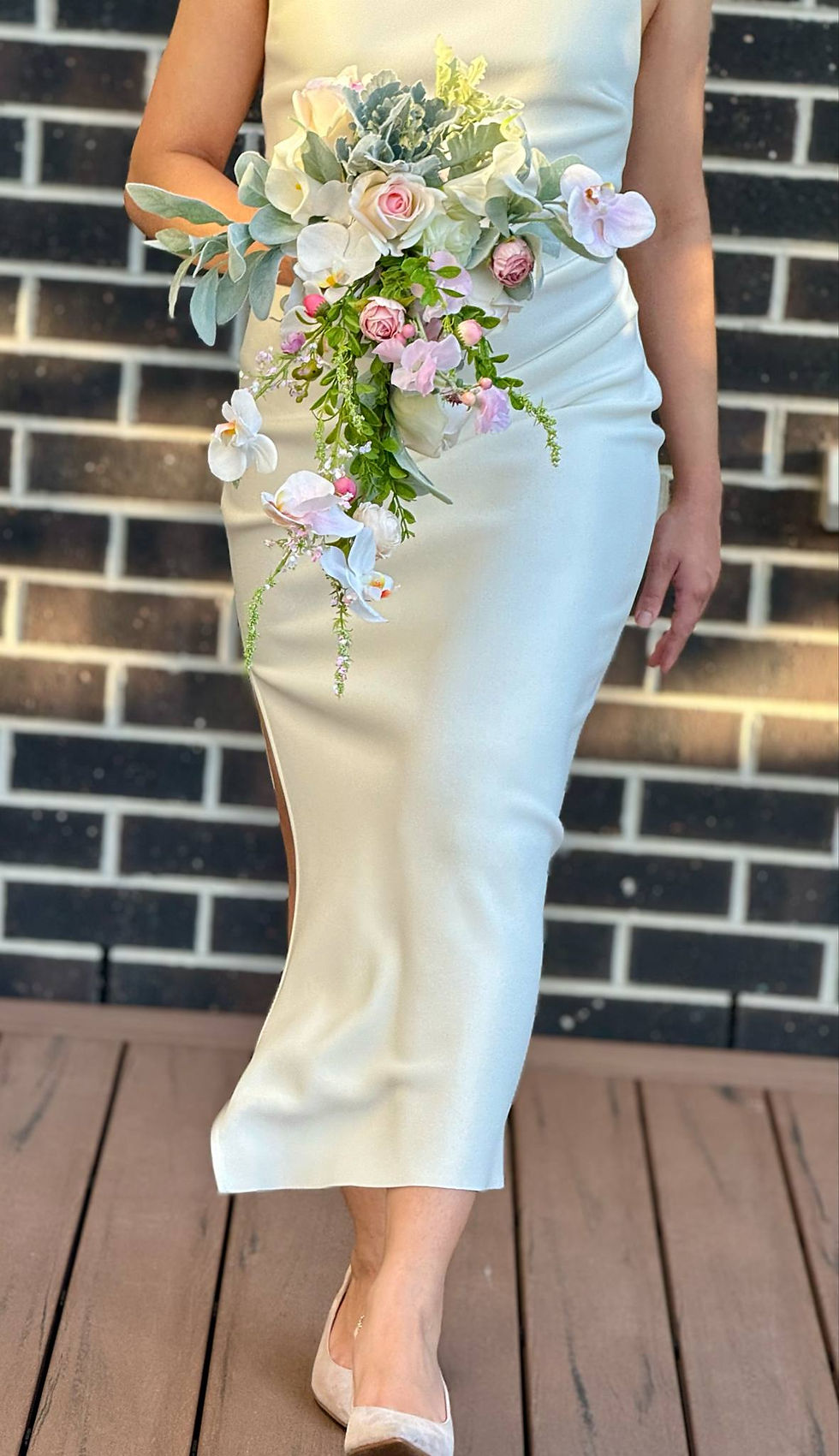 Thumbnail: Wedding bouquet, low section, showing trail with orchid, peonies and green foliage drenched in sunlight