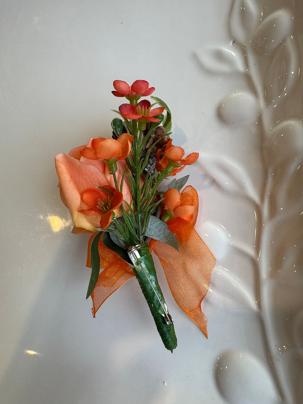 Thumbnail: Behind view of JW Weddings artificial peach rose buttonhole with organza  ribbon on white background.