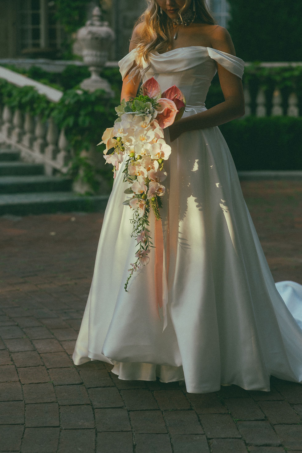 Bride holding JW Weddings Australia waterfall bouquet with cascade of real touch pink and white orchid, anthurium, calla lily.