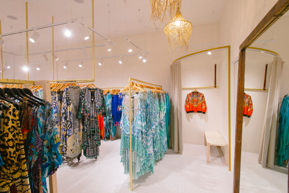 a dressing room in a store with clothes hanging on racks