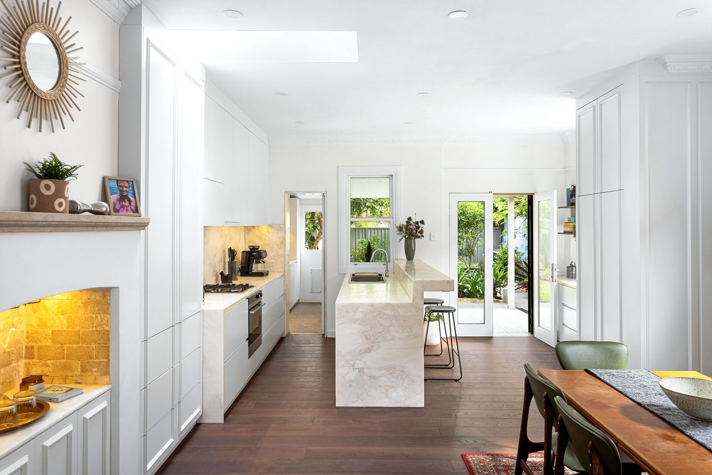 a kitchen with white cabinets and a marble counter top