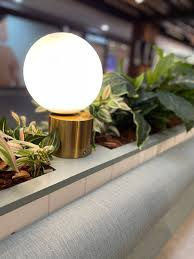 a lamp is sitting on top of a planter filled with plants .